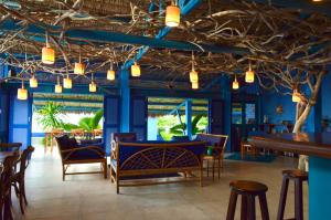 a restaurant with blue walls and wooden tables and chairs at Vila Stella Cadente in Fortim