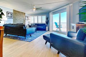 een woonkamer met een blauwe bank en een blauwe stoel bij Beach Cottage 1208 in Clearwater Beach