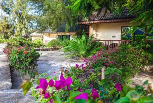 una casa con flores rosas delante de ella en VRclub Paje Palms Beach Resort en Paje