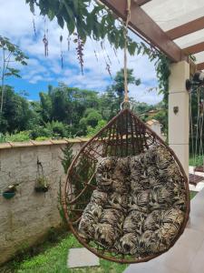 a hanging basket filled with chickens in a yard at IN HOSPEDAGEM n45 in Paraty