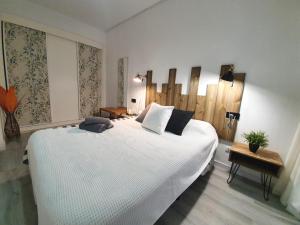 a bedroom with a large white bed in a room at Apartamentos Alamos in Málaga