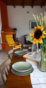 a table with green plates and a vase with a sunflower at Lily Home_Lefkada ~ Private Country house in Kondáraina