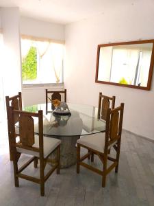 uma sala de jantar com uma mesa de vidro e cadeiras em casa HIKURI em Cancún