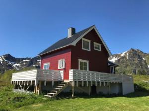 una casa roja en una colina con montañas al fondo en Cozy house with beautiful view en Valberg