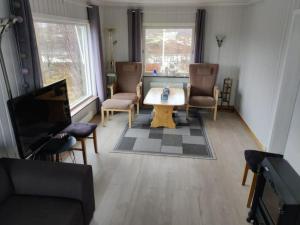 sala de estar con mesa, sillas y TV en Cozy house with beautiful view en Valberg