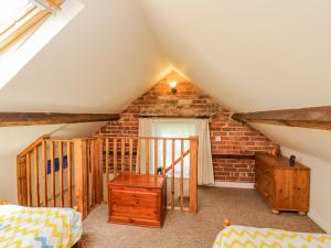 een zolderkamer met een trap en een bakstenen muur bij Parkfield Cottage in Sturminster Marshall