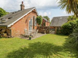 une maison en briques avec une table et des chaises dans une cour dans l'établissement Parkfield Cottage, à Sturminster Marshall