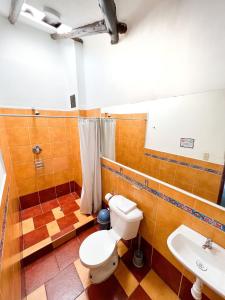 y baño con aseo y lavamanos. en Hostal Teatro Inka, en Cusco