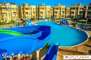 einem großen Pool mit Rutsche in einem Resort in der Unterkunft blue bay sokhna aqua park - مارسيليا بلو باى السخنه -عائلات فقط in Ain Suchna