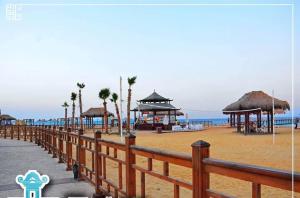 a wooden fence on a beach with buildings and the ocean at blue bay sokhna aqua park - مارسيليا بلو باى السخنه -عائلات فقط in Ain Sokhna