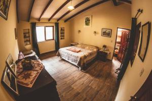 1 dormitorio con 1 cama y suelo de madera en Hostel Serena, en Samaipata