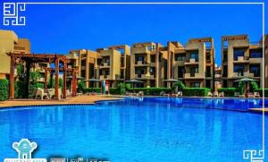 ein großer Pool vor einigen Apartments in der Unterkunft blue bay sokhna aqua park - مارسيليا بلو باى السخنه -عائلات فقط in Ain Suchna