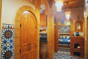 een kamer met een boog en een kamer met 2 bedden bij Riad Milal in Essaouira