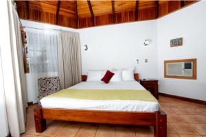 Acacia Playa Hermosa في بلايا هيرموسا: غرفة نوم عليها سرير ومخدة حمراء