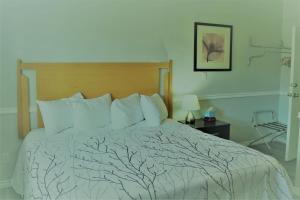 a bed in a hotel room with a tree patterned blanket at Westridge Motor Inn in Osoyoos