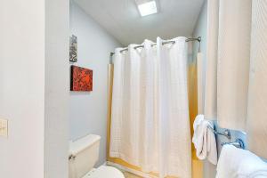 a bathroom with a white shower curtain and a toilet at Fall Creek Resort Pond View Escape in Branson