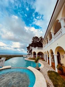 卡布瑞拉的住宿－El Castillo Tropical，享有带游泳池的建筑的外部景色