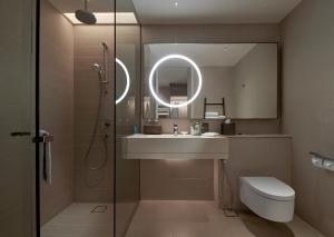 a bathroom with a sink and a shower with a mirror at Amari Kuala Lumpur in Kuala Lumpur