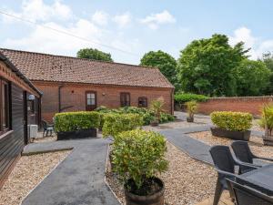 a courtyard with chairs and a brick building at Willow in Wood Norton