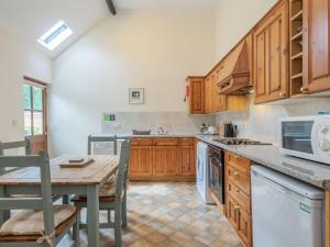 uma cozinha com armários de madeira e uma mesa de madeira e uma mesa e cadeiras em Willow em Wood Norton