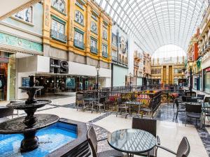 a shopping mall with tables and chairs and a glass ceiling at West Edmonton Mall Inn in Edmonton