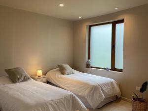 Duas camas num quarto com uma janela em ANTAKARANA em Lozano