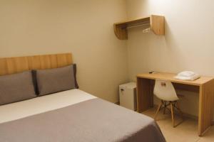ein Schlafzimmer mit einem Bett und einem Schreibtisch mit Telefon in der Unterkunft HOTEL RIOS - BALSAS in Balsas