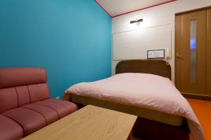 大阪市にあるホテル フー難波（大人専用）のベッド、ソファ、椅子が備わる客室です。