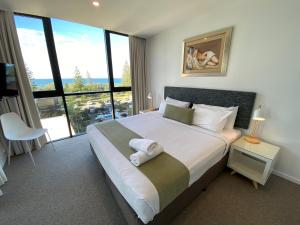 a bedroom with a large bed with a large window at Boardwalk Burleigh Beach - Official in Gold Coast +80 photos