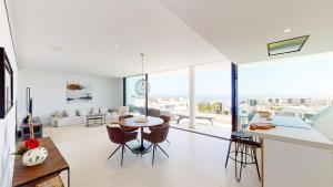 een keuken en een woonkamer met een tafel en stoelen bij Higueron West II - Luxury new built 3 bed apartmen in Fuengirola