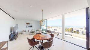 een eetkamer en een woonkamer met een tafel en stoelen bij Higueron West II - Luxury new built 3 bed apartmen in Fuengirola