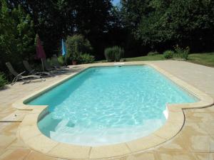 a swimming pool with blue water in a yard at Gîte Mauzens-et-Miremont, 6 pièces, 10 personnes - FR-1-616-254 in Mauzens-et-Miremont