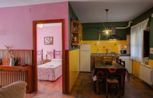 a kitchen with a table and a room with a bed at Casas Rurales Acebuche, OTOÑO MÁGICO en Valle del Ambroz in Casas del Monte