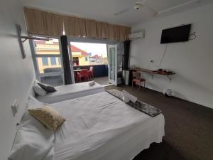 a bedroom with two beds and a large window at Ayr Hotel in Ayr