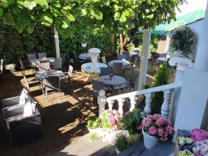 un patio con mesas, sillas y flores en Restaurant-Hotel Dimitra, en Alsbach-Hähnlein