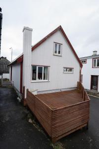 une grande terrasse en bois devant une maison dans l'établissement 4 BR House / Scenic Village / Nature / Hiking, à Við Gjógv