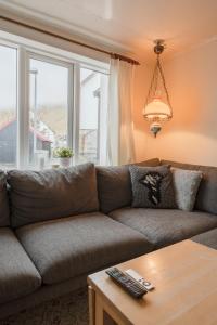 een woonkamer met een bank en een raam bij 4 BR House / Scenic Village / Nature / Hiking in Við Gjógv