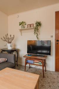 ein Wohnzimmer mit einem TV und einem Couchtisch in der Unterkunft 4 BR House / Scenic Village / Nature / Hiking in Við Gjógv