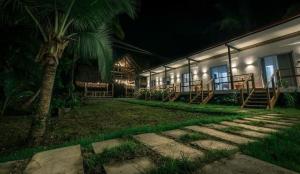 a building with a palm tree in front of it at night at Somewhere in Bocas del Toro