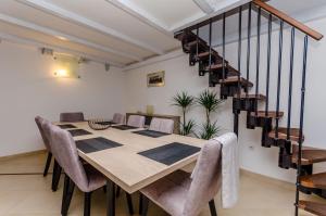 ein Esszimmer mit einem Tisch, Stühlen und einer Treppe in der Unterkunft Apartment Dora in Trogir
