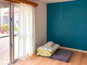石垣島にある民宿イラヨイのベッド1台と大きな窓が備わる客室です。
