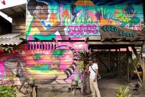 a man standing in front of a wall covered in graffiti at Coco House - Playa La Barra in Buenaventura