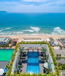 an aerial view of a resort with a pool and the beach at Paris Deli Danang Beach Hotel in Danang