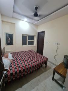 Un dormitorio con una cama y una mesa. en Ever Green Guest House Travel & PG, en Nueva Delhi