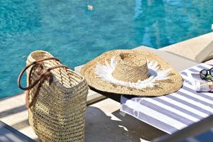a straw hat and a bag sitting on a table by a pool at U Paesolu in Sainte-Lucie de Porto-Vecchio