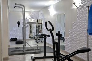 un gimnasio con cintas de correr y elípticas en una habitación en U Paesolu en Sainte-Lucie de Porto-Vecchio