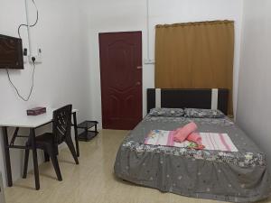 um quarto com uma cama, uma mesa e uma secretária em Depulauserai Roomstays em Pekan