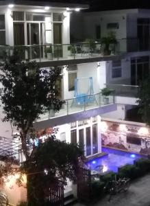 Biệt thự Sao Biển - SB118 FLC Sầm Sơn Resort في سام سون: مبنى سكني فيه مسبح بالليل