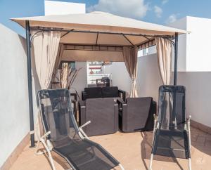 two chairs under a gazebo on a patio at GoToSeville FERIA APARTMENTS in Seville