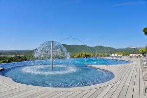 a fountain in the middle of a swimming pool at U Paesolu in Sainte-Lucie de Porto-Vecchio